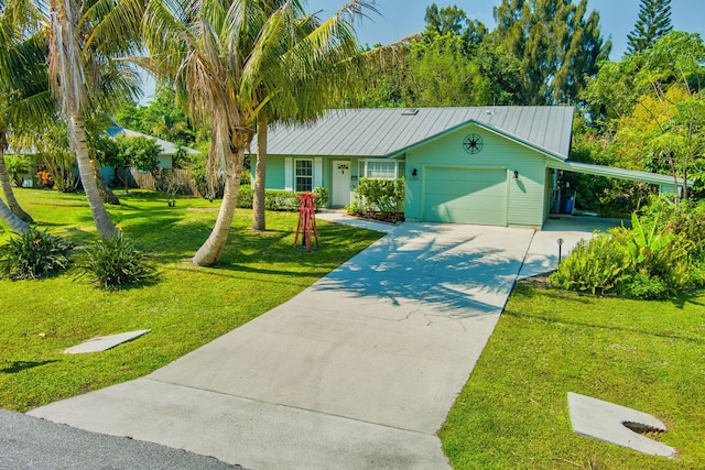 ranch-style house featuring a front yard, driveway, a carport, a garage, and metal roof