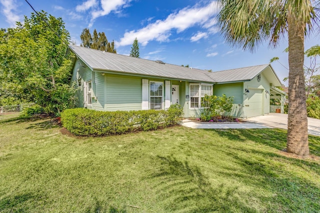 single story home with a front yard, a garage, driveway, and metal roof