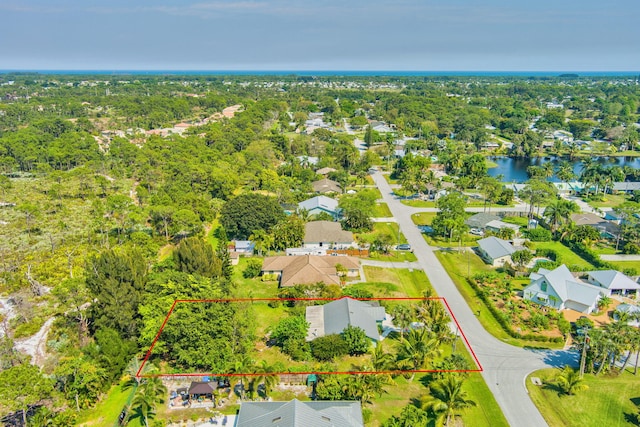 bird's eye view featuring a wooded view, a water view, and a residential view