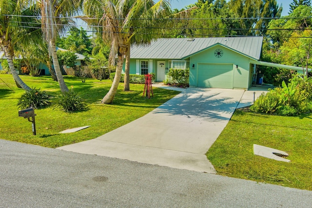 view of front facade with a front yard, concrete driveway, an attached garage, and metal roof