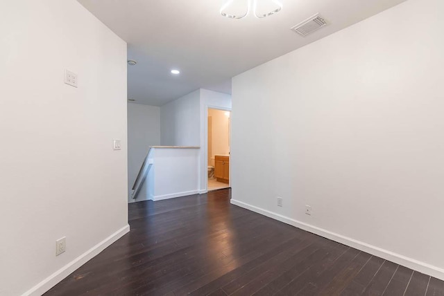 spare room with dark wood-style floors, visible vents, recessed lighting, and baseboards