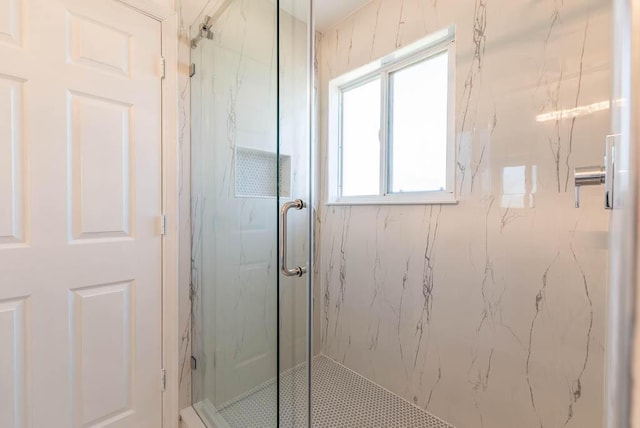 bathroom featuring a marble finish shower