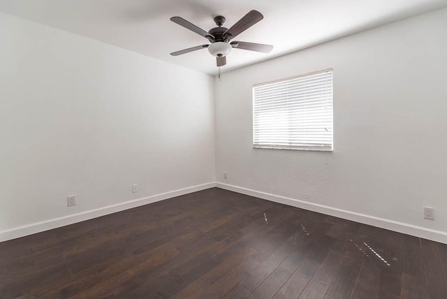 empty room with baseboards, dark wood-type flooring, and a ceiling fan