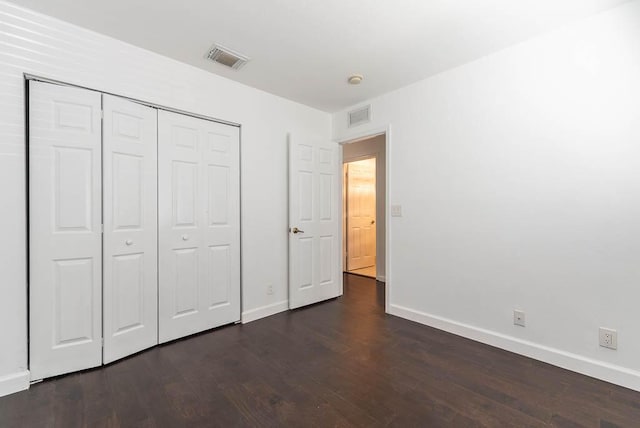 unfurnished bedroom with dark wood finished floors, visible vents, and baseboards