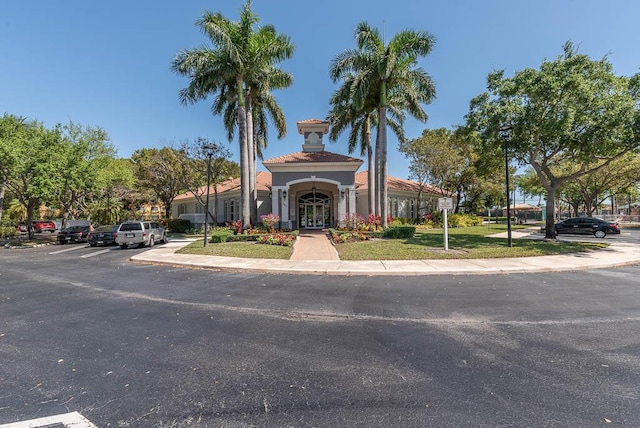 view of front of house featuring a tile roof and uncovered parking