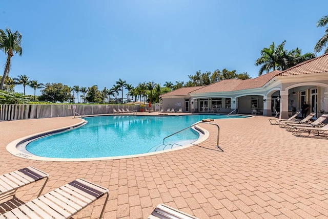 pool with a patio and fence