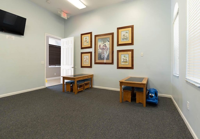 misc room with dark colored carpet and baseboards