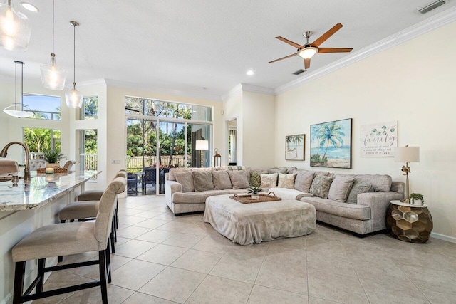 living area with visible vents, crown molding, a high ceiling, and light tile patterned floors