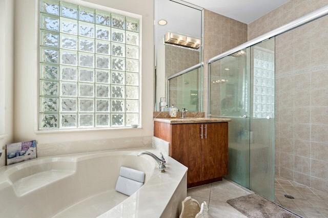 full bath featuring a garden tub, a shower stall, vanity, and tile patterned floors