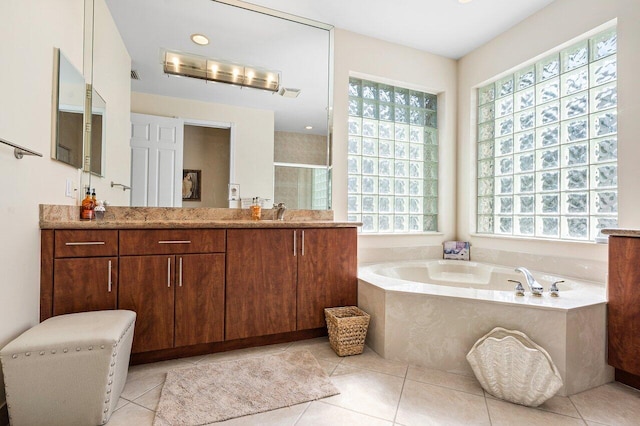 bathroom featuring a stall shower, vanity, a bath, and tile patterned floors