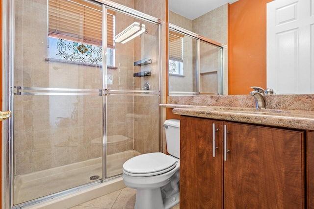 bathroom featuring a stall shower, tile patterned flooring, vanity, and toilet