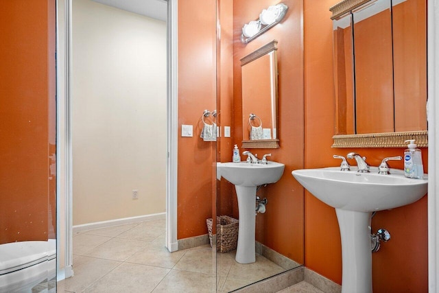 half bath with baseboards and tile patterned floors