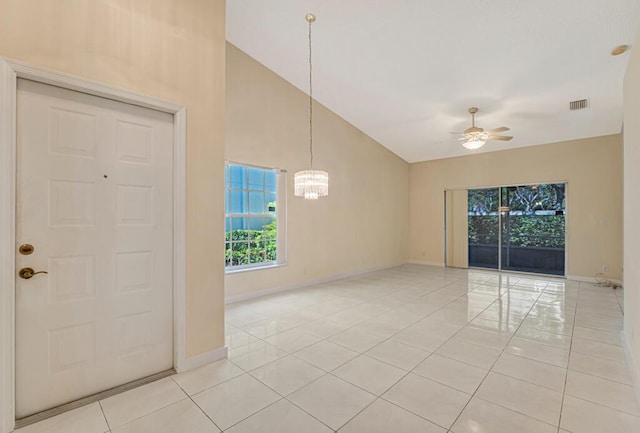 spare room with light tile patterned floors, baseboards, visible vents, high vaulted ceiling, and ceiling fan with notable chandelier