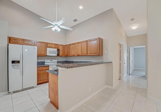 kitchen featuring white appliances, light tile patterned floors, high vaulted ceiling, and a sink