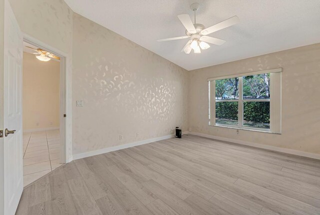 unfurnished room with light wood-style floors, visible vents, baseboards, and a ceiling fan