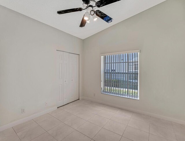 unfurnished bedroom with a closet, visible vents, vaulted ceiling, and baseboards