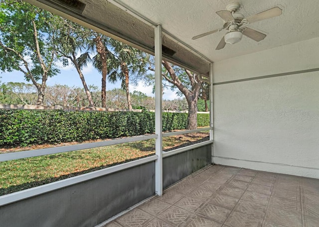 unfurnished sunroom with ceiling fan