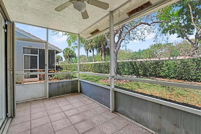 unfurnished sunroom with ceiling fan