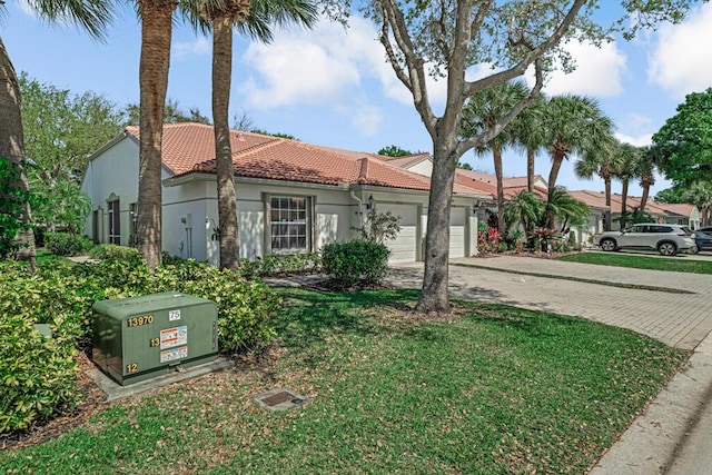 mediterranean / spanish-style house featuring an attached garage, a tile roof, decorative driveway, and stucco siding