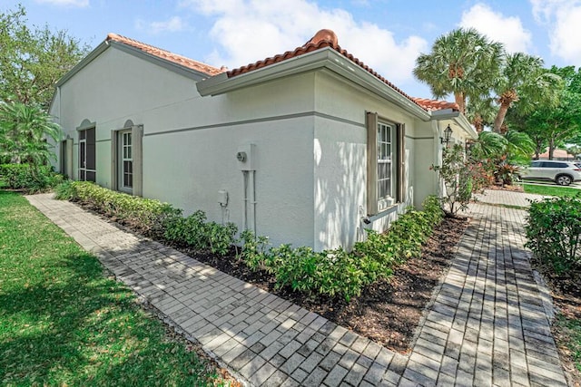 view of property exterior featuring a tiled roof and stucco siding