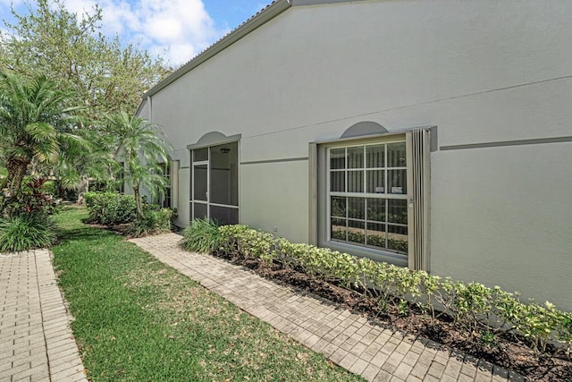 view of property exterior featuring a lawn and stucco siding