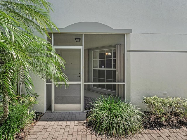 view of exterior entry with stucco siding