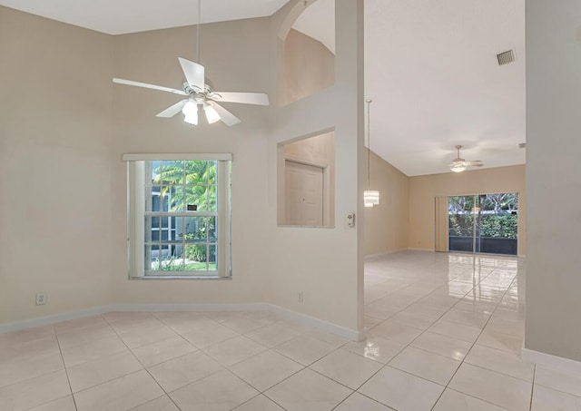 empty room featuring ceiling fan, light tile patterned floors, visible vents, and a wealth of natural light