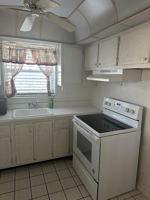 kitchen with light tile patterned floors, under cabinet range hood, a sink, light countertops, and white range with electric cooktop