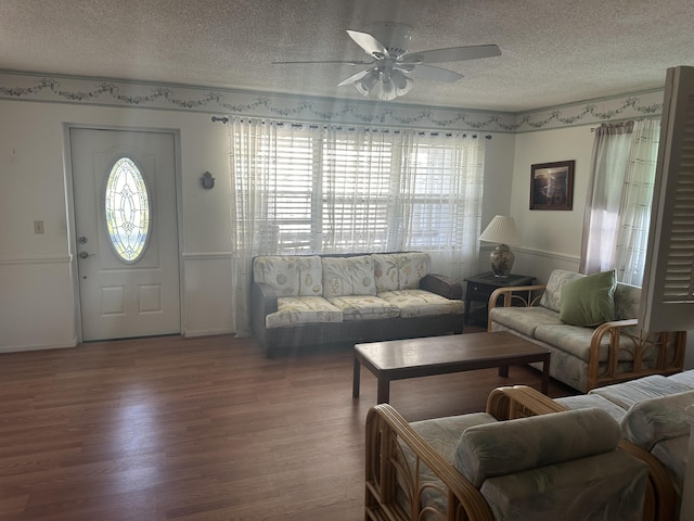 living area with a textured ceiling, wood finished floors, and a ceiling fan