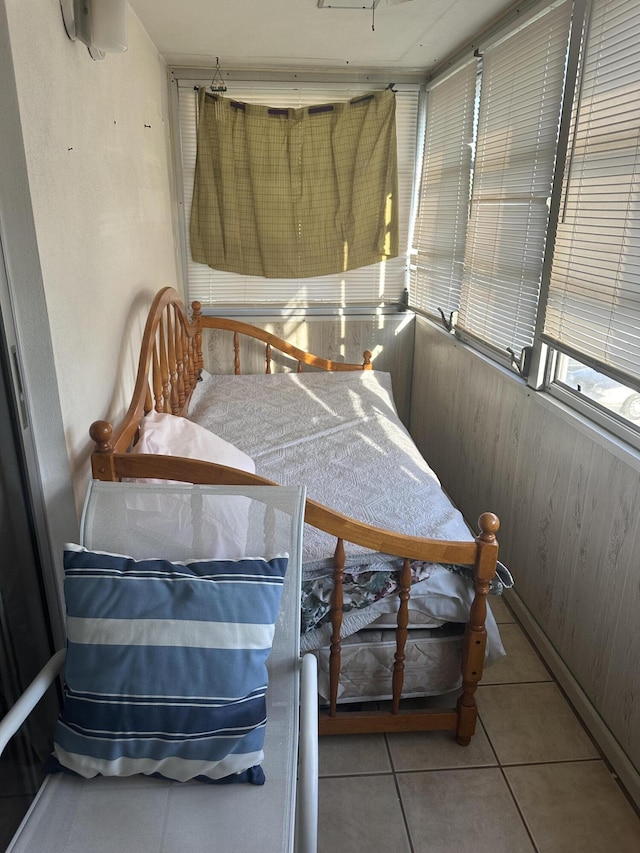 bedroom featuring wood walls and tile patterned floors