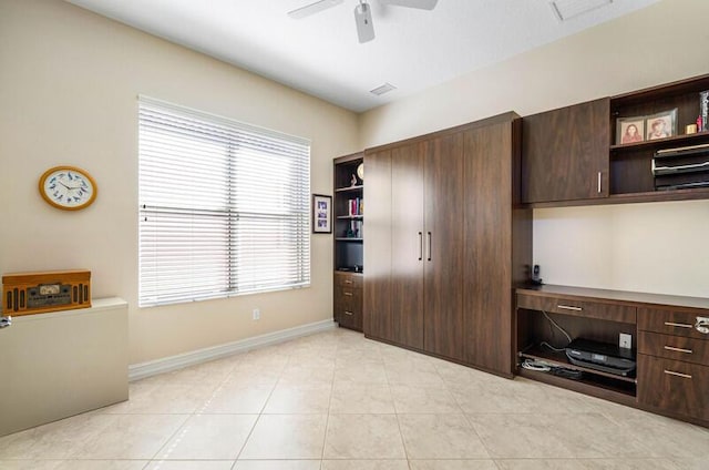 bedroom with visible vents, ceiling fan, baseboards, light tile patterned flooring, and built in study area