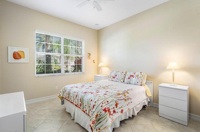 bedroom featuring baseboards, light tile patterned flooring, and a ceiling fan