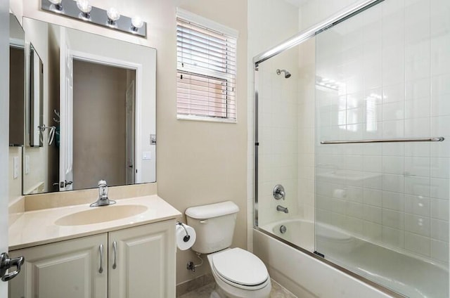 bathroom featuring vanity, toilet, and shower / bath combination with glass door