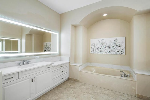 full bathroom featuring vanity, a garden tub, and tile patterned flooring