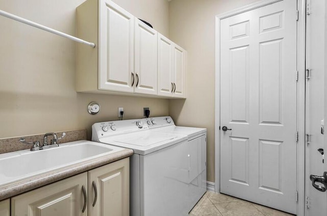 clothes washing area featuring separate washer and dryer, light tile patterned floors, cabinet space, and a sink