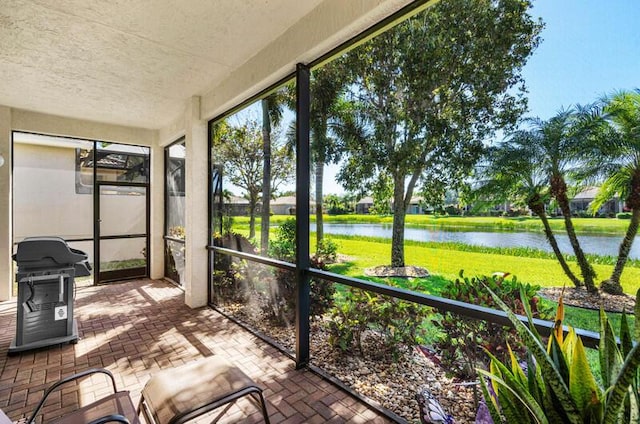 unfurnished sunroom featuring a water view