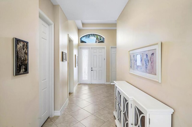 foyer featuring light tile patterned floors and baseboards