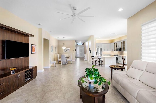 living room featuring recessed lighting, baseboards, and ceiling fan