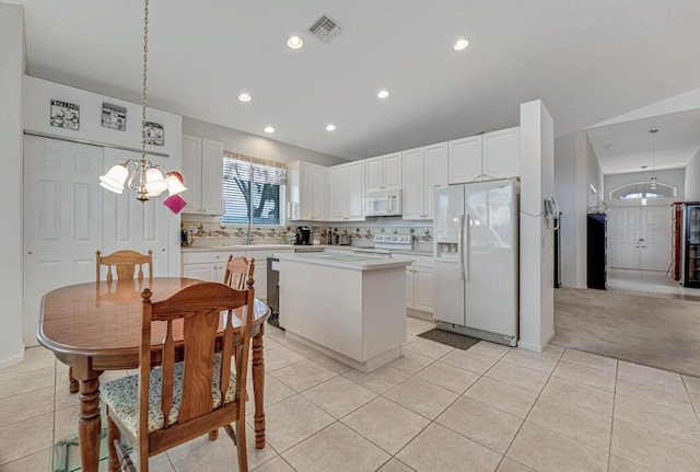kitchen featuring a center island, white appliances, an inviting chandelier, visible vents, and light countertops