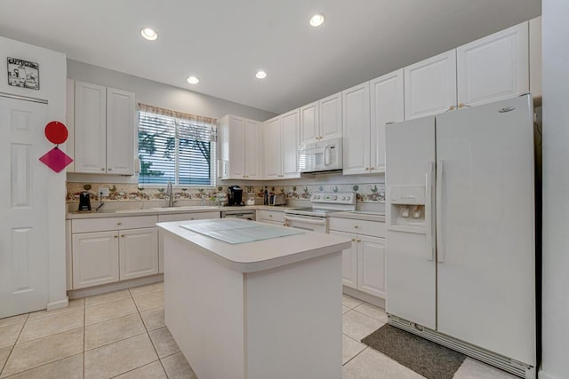 kitchen featuring light tile patterned floors, white cabinetry, white appliances, light countertops, and a kitchen island
