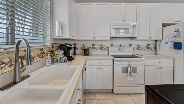 kitchen with white cabinets, a sink, and white appliances