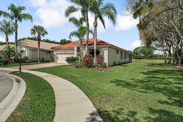 mediterranean / spanish house with an attached garage, stucco siding, driveway, and a front lawn