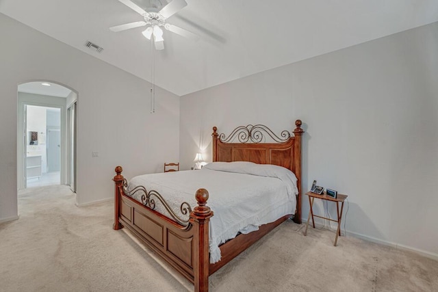 bedroom featuring light colored carpet, visible vents, vaulted ceiling, ceiling fan, and arched walkways