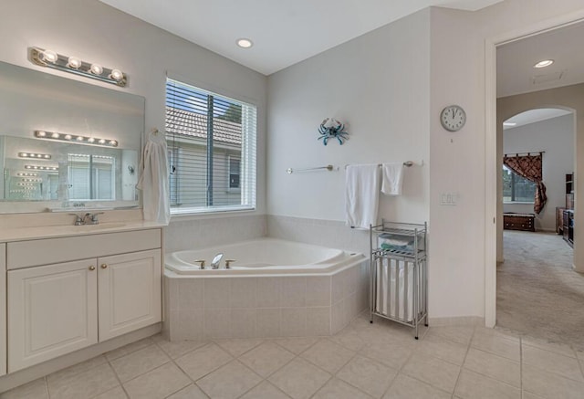 full bathroom with tile patterned floors, vanity, and a garden tub