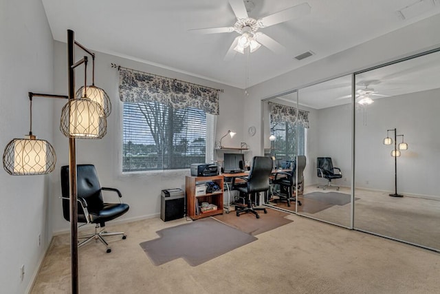 carpeted home office with baseboards, a ceiling fan, and visible vents