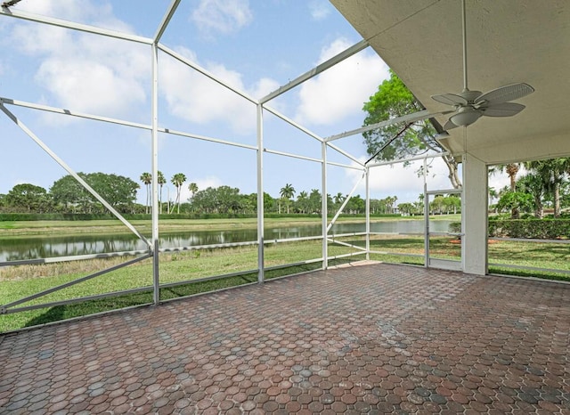 unfurnished sunroom featuring a ceiling fan and a water view