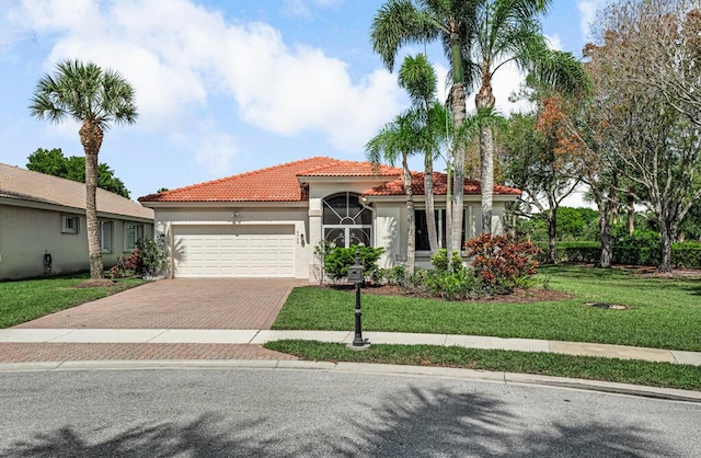 mediterranean / spanish home featuring a garage, a tiled roof, stucco siding, a front lawn, and decorative driveway