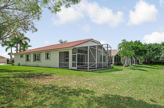 back of house featuring a lanai, stucco siding, a tiled roof, and a lawn