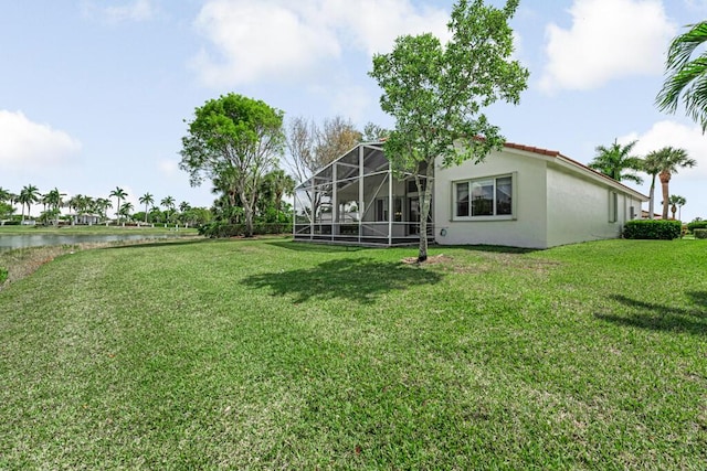 view of yard with a water view and a lanai