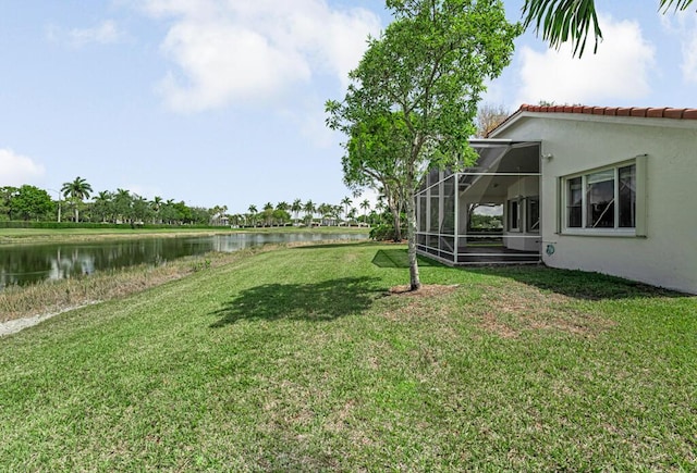 view of yard with a water view and glass enclosure